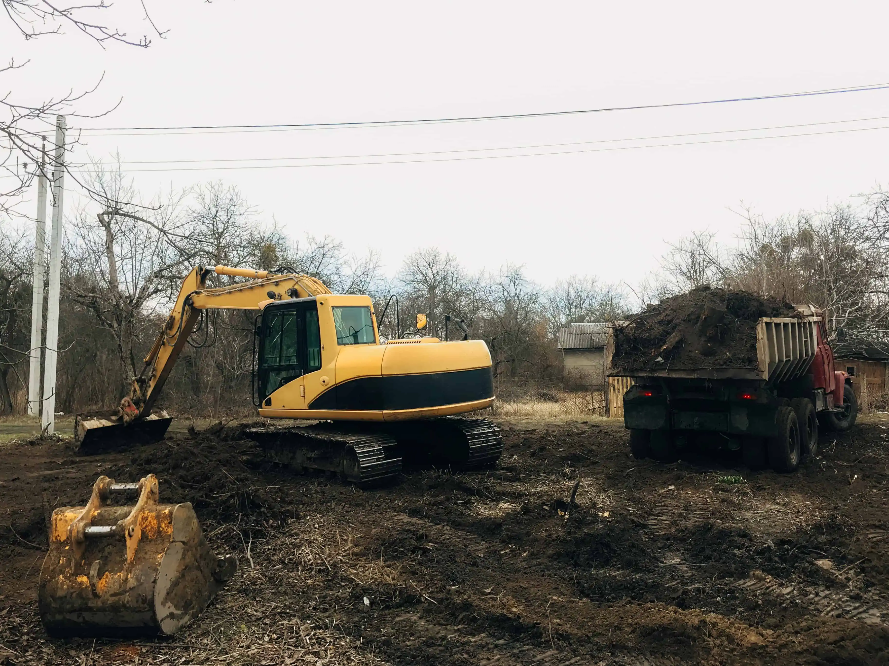 Bulldozer clearing land from old trees, roots and branches with dirt and trash